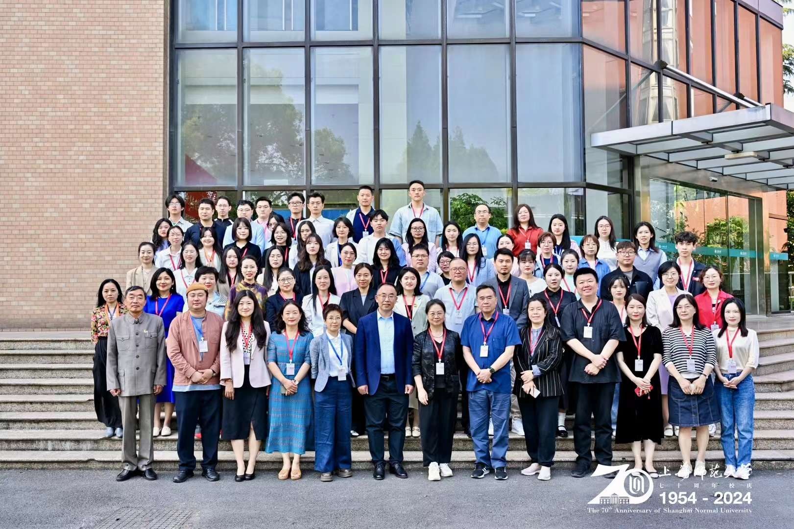 Symposium participants posing on the steps at the venue entrance.